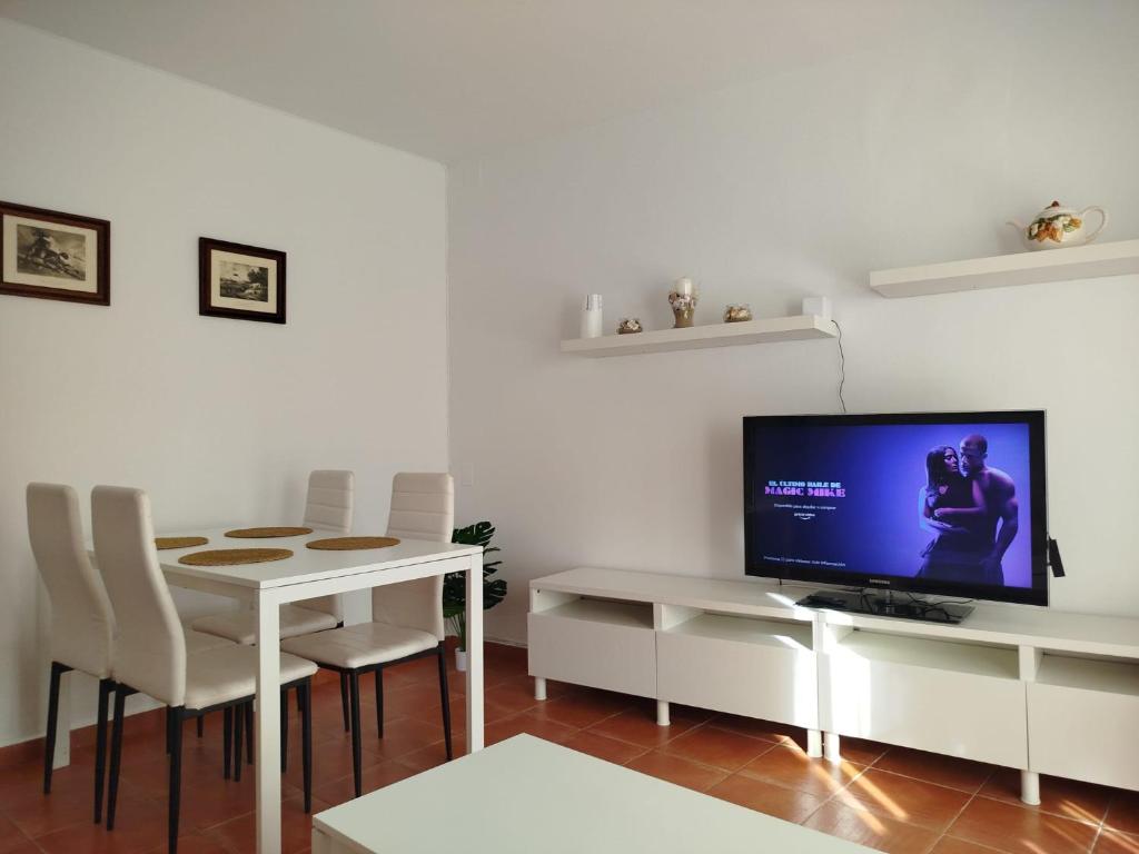 a living room with a white table and a television at Aires de Chipiona Apartamento A in Chipiona