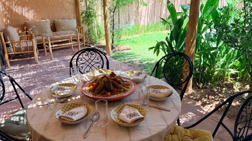 a table with a plate of food on it at Villa tawarda in Oumnas