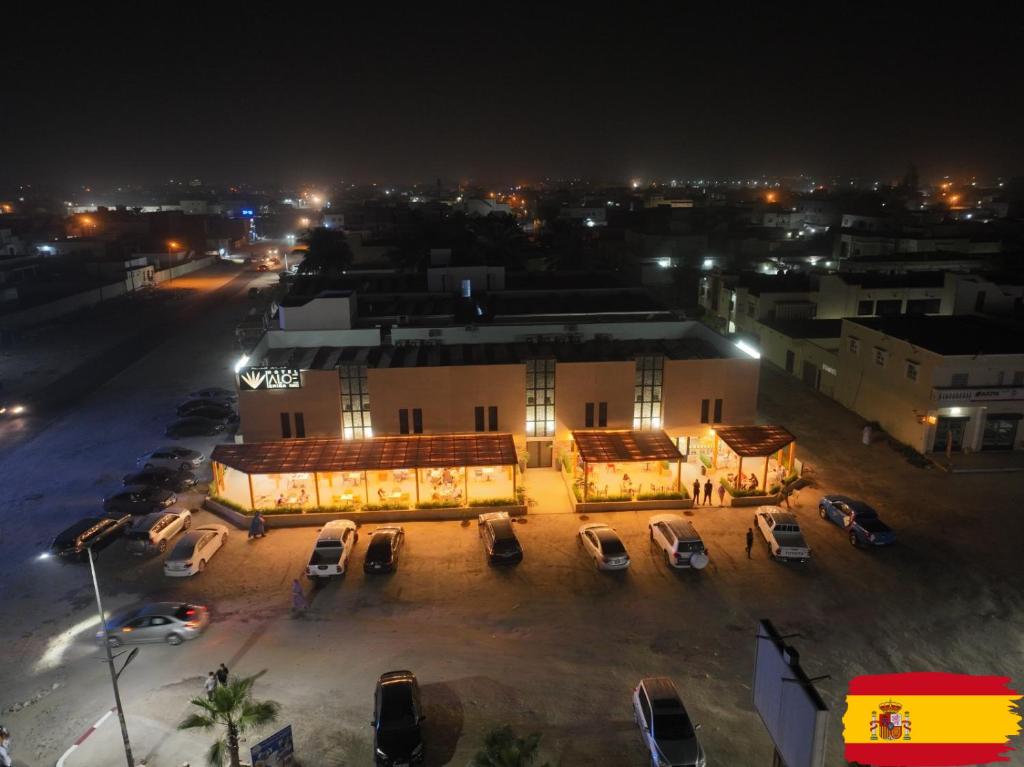 a building with cars parked in a parking lot at night at Hotel Aloe Emira NKC in Nouakchott