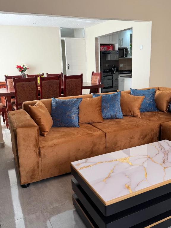 a brown couch in a living room with a table at Selah House in Harare