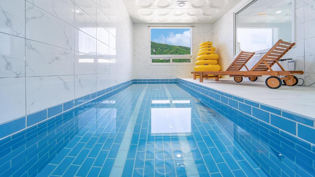 a pool with two lounge chairs and a swimming pool at Gapyeong Boreum-Dal Poolvilla in Gapyeong