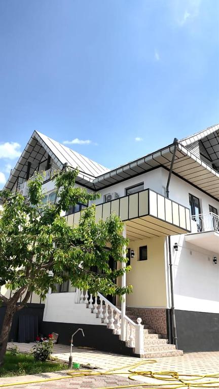 a white building with a staircase in front of it at Elegance Hotel Osh in Osh