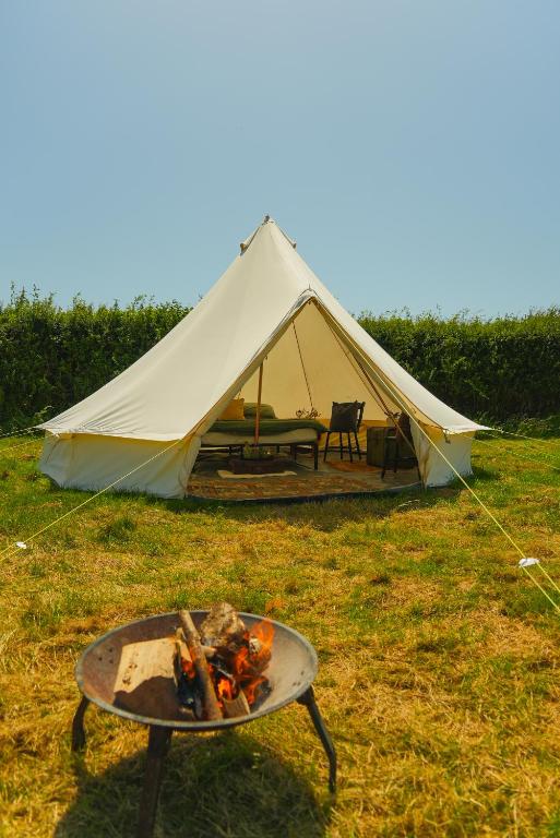 a tent and a grill with a fire in front at Devon Belltents - South Milton in Hope Cove