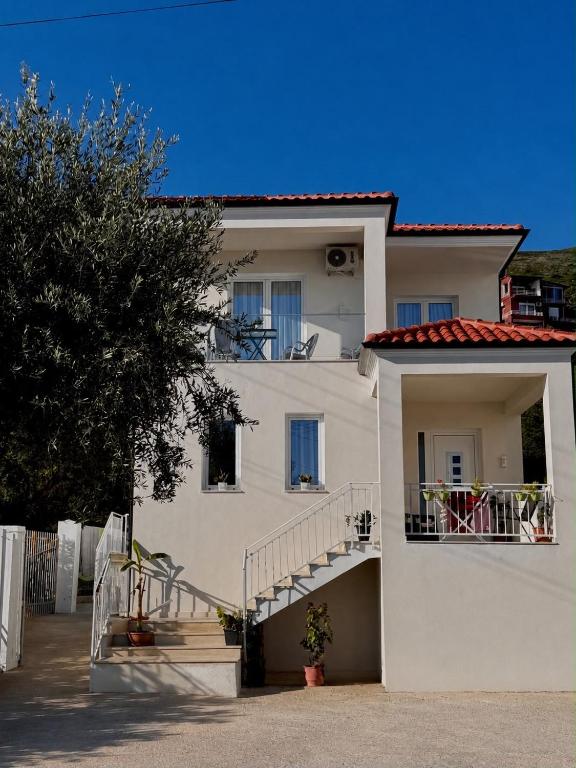 a white building with a staircase in front of it at Villa Thalassa Lal'Andrea in Dhërmi