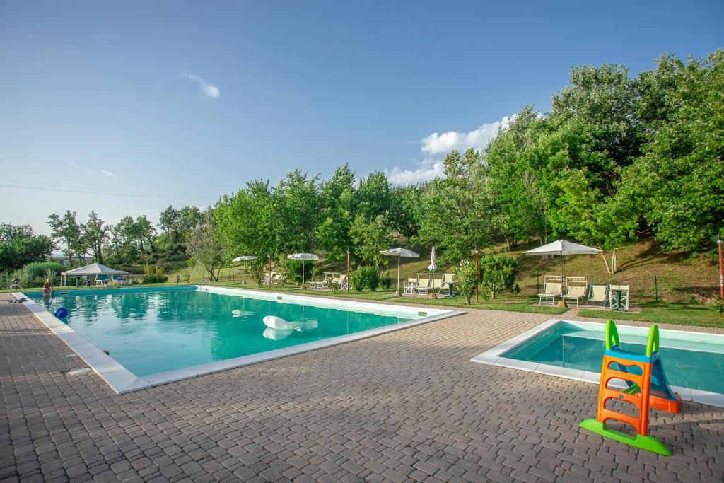 a pool with two chairs and a swan in the water at Tenuta Moriano in Montespertoli