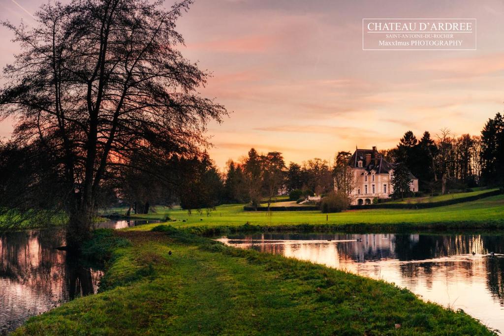 una casa junto a un río con un edificio en Château d'Ardrée, en Saint-Antoine-du-Rocher