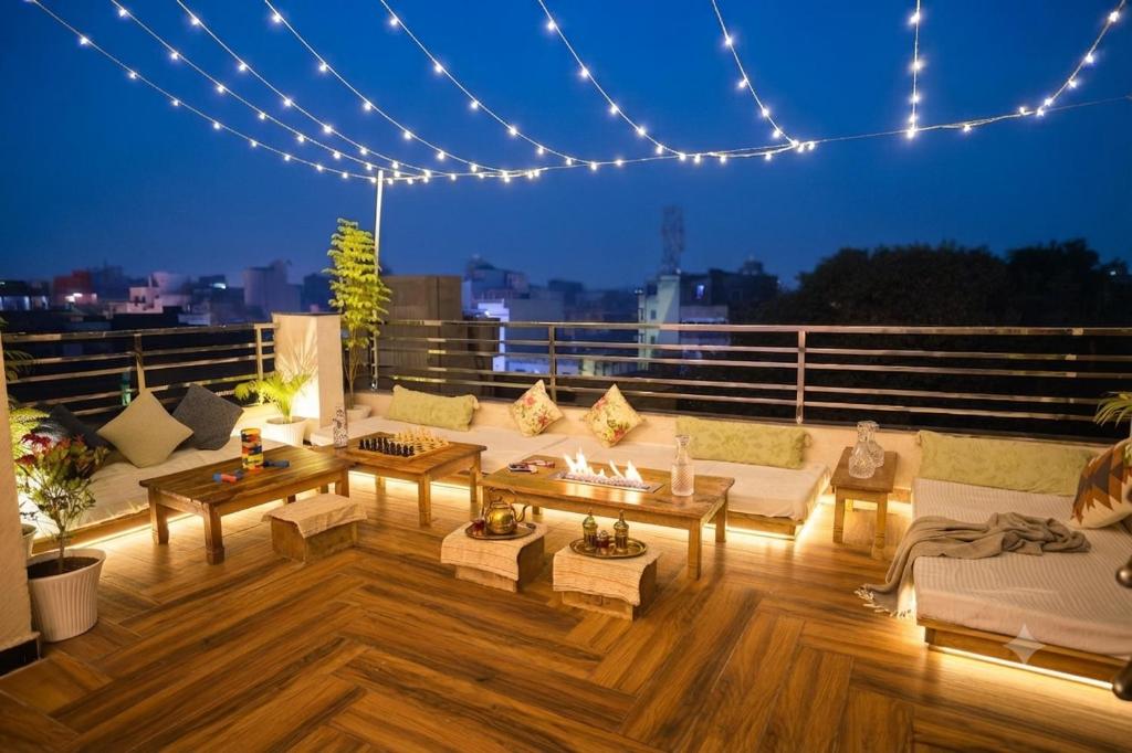 a living room with couches and tables on a balcony at 3 Raahi Varanasi in Varanasi