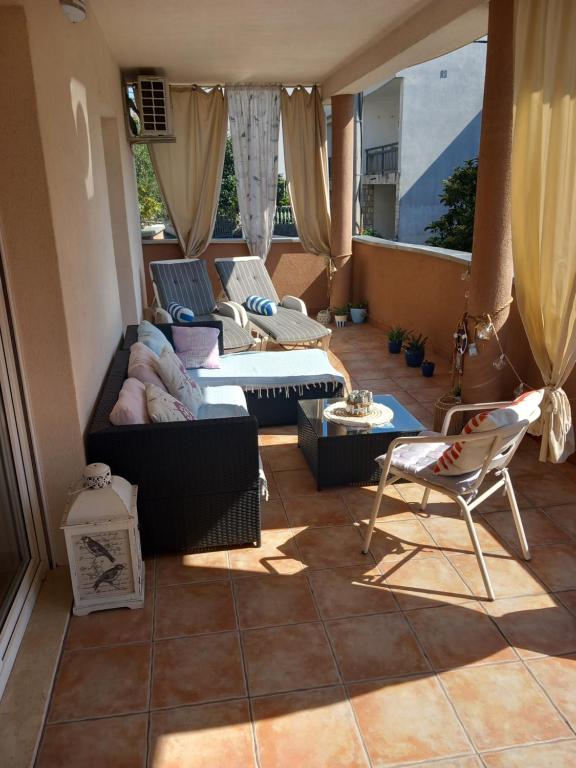 una sala de estar con un sofá, una mesa y sillas en Apartman Miletic, en Mostar