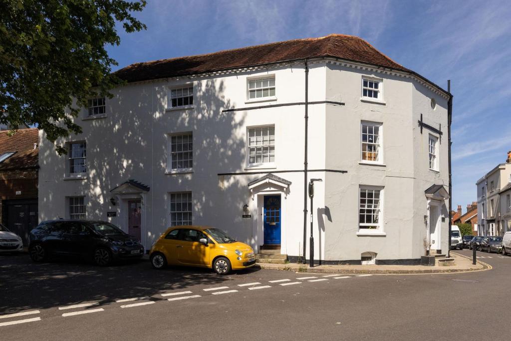 a yellow car parked in front of a white building at NEW - Herricks by The Butler Collection in Arundel