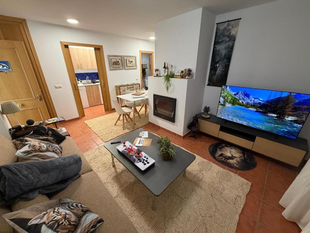 a living room with a large flat screen tv at La Sima del Anillo in Cardaño de Abajo