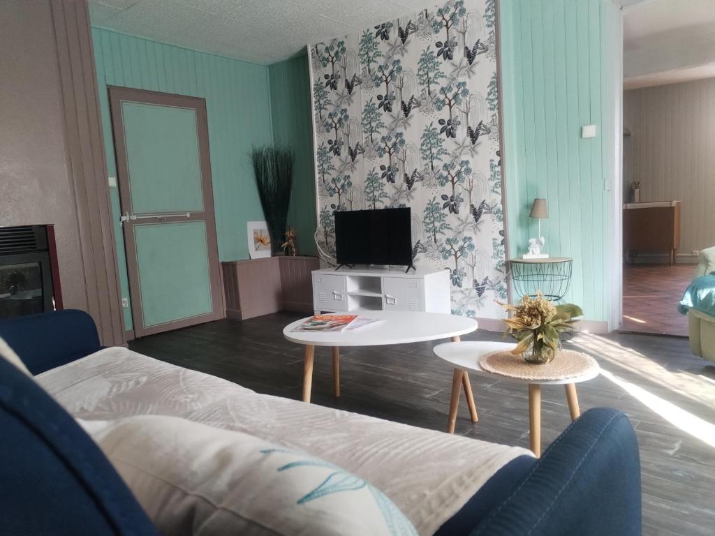 a living room with a couch and a tv at Le Nichoir de Lesmont in Lesmont