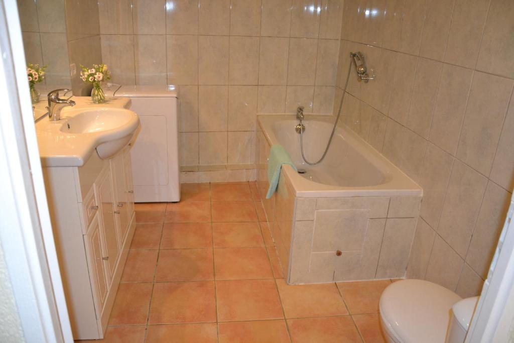een badkamer met een bad, een wastafel en een toilet bij Apartment the Haven in Cucugnan