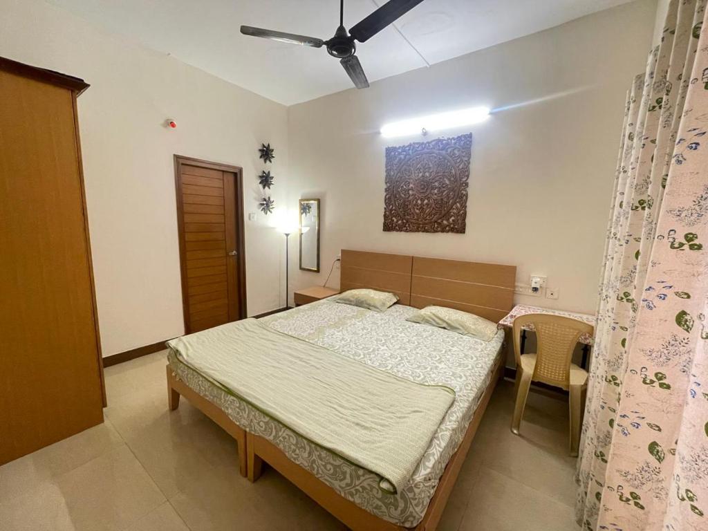 a bedroom with a bed and a ceiling fan at Neha's Homestay in Mysore