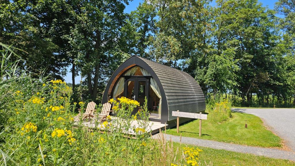 a small cabin in the middle of a garden at Tiny House De Hagekrûper in Westergeest