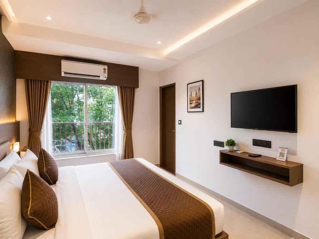 a bedroom with a large bed and a flat screen tv at The Kingsway Suites in Nagpur