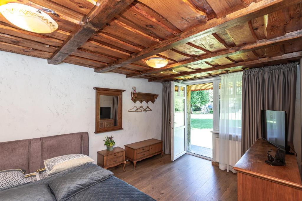 a living room with a couch and a tv at Laukdvaris in Laukžemė
