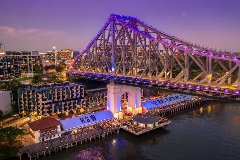 a bridge over the water at night with a city at The Alva Hotel Brisbane, Vignette Collection by IHG in Brisbane