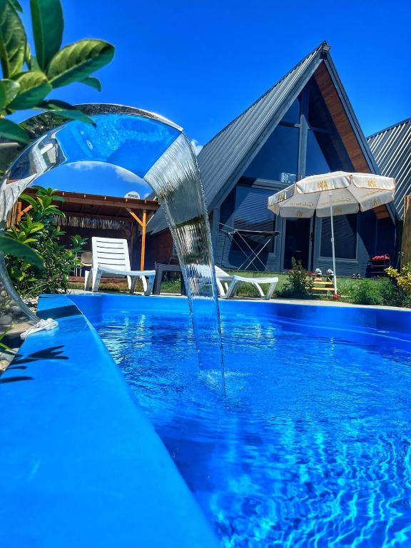 a pool with a water fountain in front of a house at Şimal Bungalov in Samsun