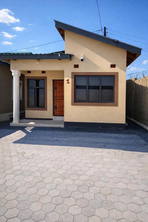 a house with a driveway in front of it at Peaceful Home Self-catering Solar Backed Apartment in Lusaka