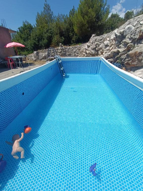 a person holding a ball in a swimming pool at Studio Apartment Sanja 4 in Neum