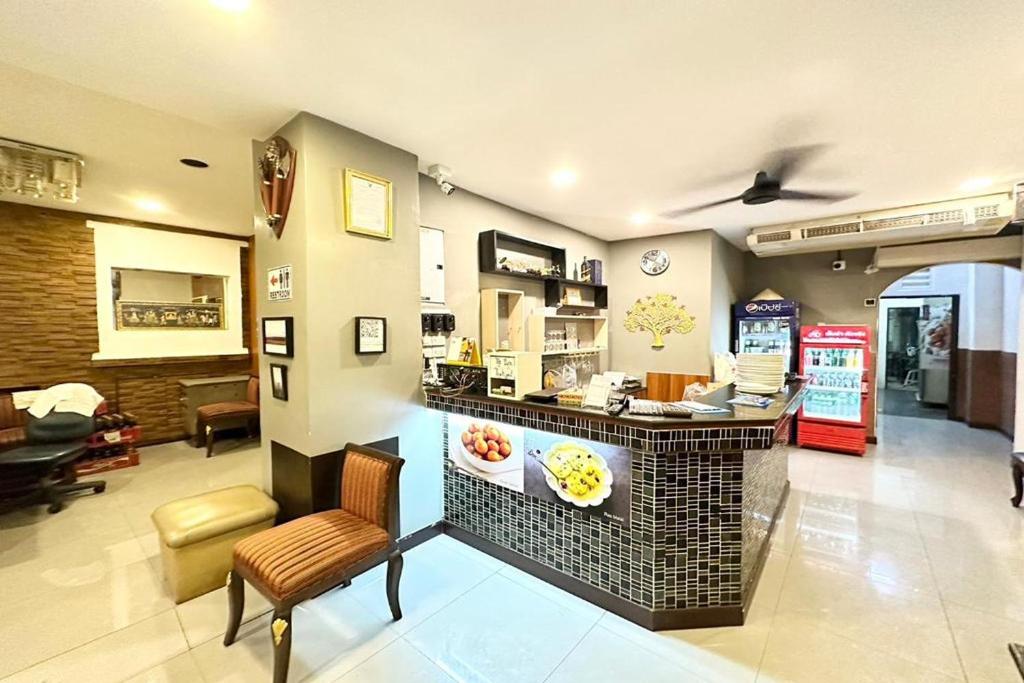 a restaurant with a counter and chairs in a room at Baan at Khaosan Hotel in Bangkok
