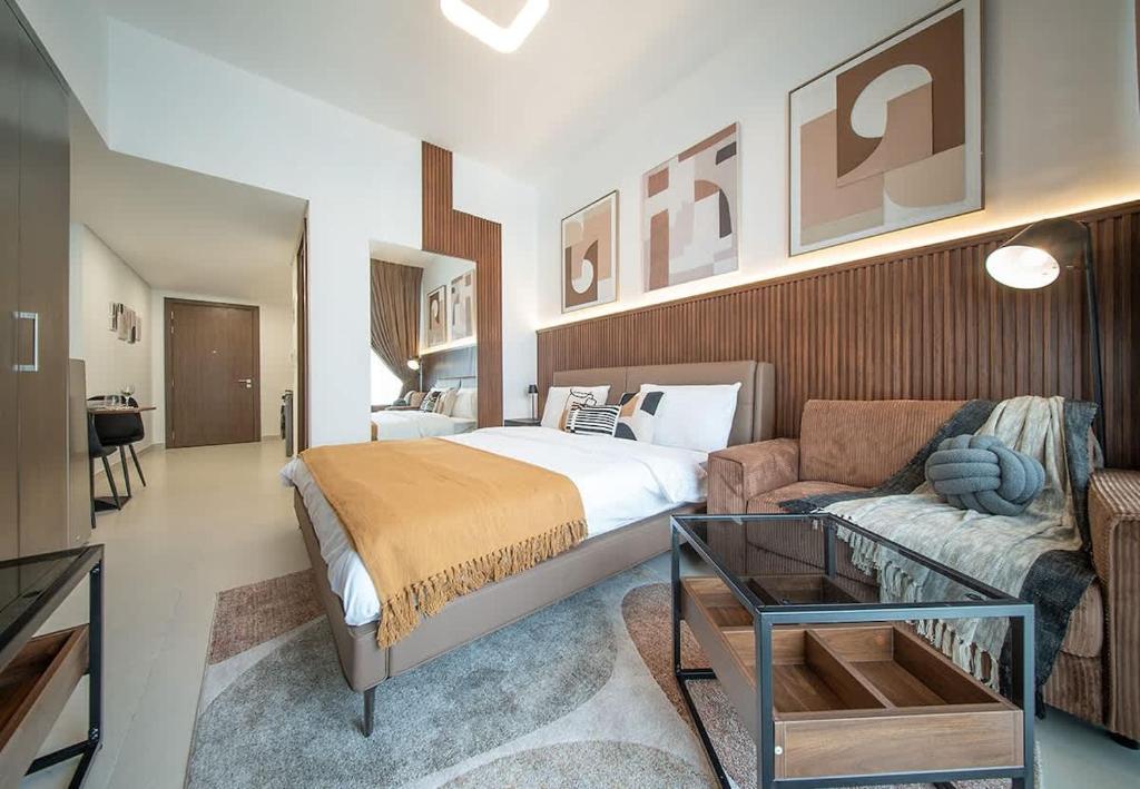 a hotel room with a bed and a couch at Stunning Oceanfront Studio Stay - Blue Bay Walk Pool & Gym in Sharjah
