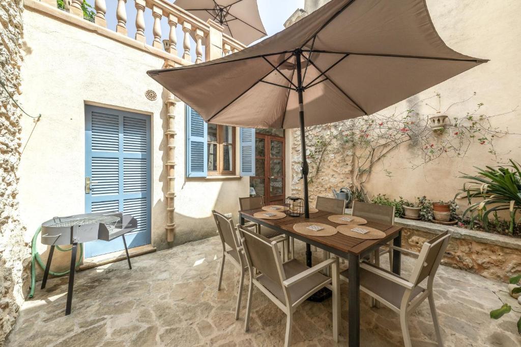 a table and chairs with an umbrella on a patio at Can Vallori in Sencelles