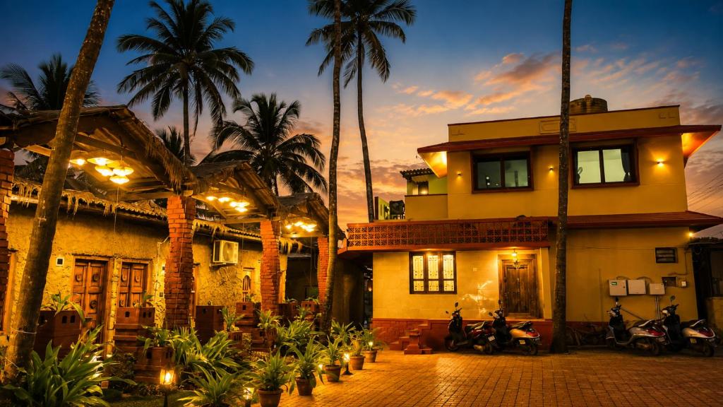 a building with palm trees and motorcycles in front of it at The Ocean Crown in Udupi