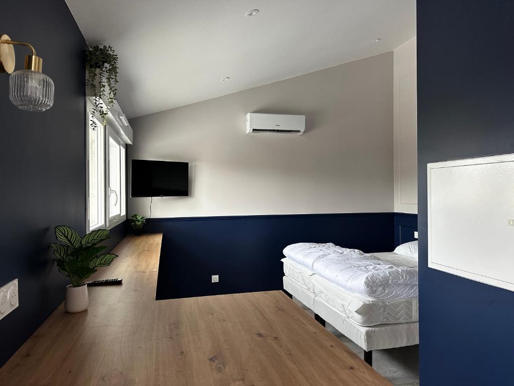 a bedroom with a bed and a tv on the wall at Studio Céleste - Clim - Parking gratuit - Proche CNPE Blayais in Braud-et-Saint-Louis