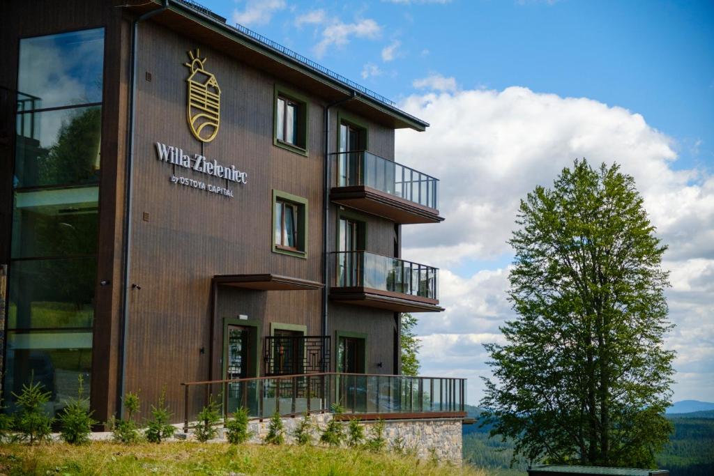 a building with a sign on the side of it at Willa Zieleniec - apartamenty z Ogrodem SPA in Duszniki Zdrój