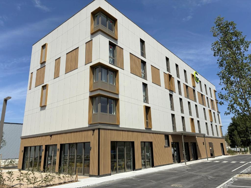 a large white building with windows on a street at B&B HOTEL Amiens Sud in Amiens