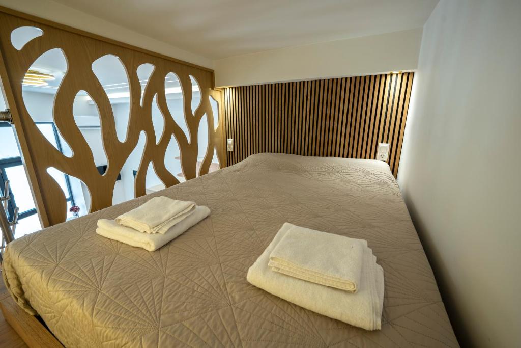 ein Schlafzimmer mit einem Bett, auf dem zwei Handtücher liegen in der Unterkunft Estia Loft in Giannitsa