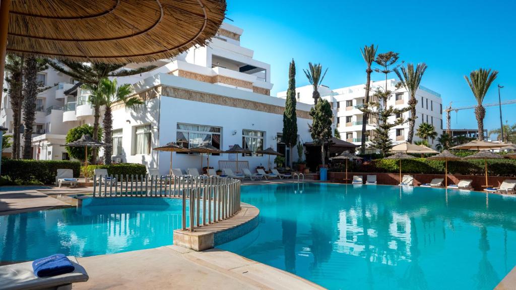 a swimming pool in front of a building at Intouriste Hotel & Suites in Agadir