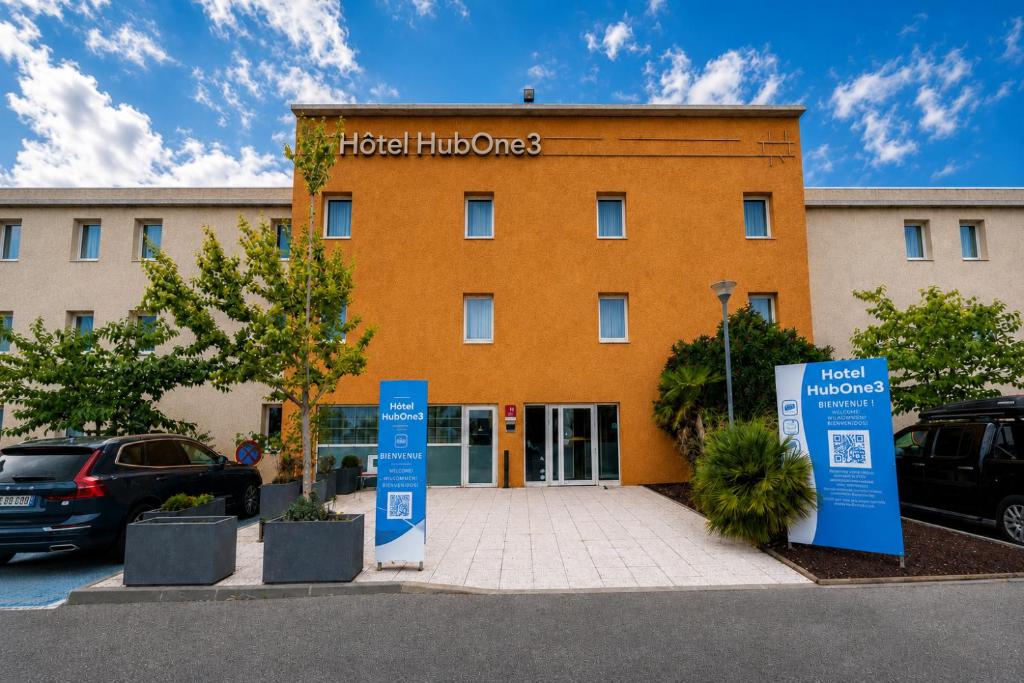a hotel with signs in front of a building at HubOne3 Istres in Istres