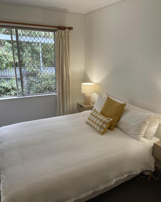 a bedroom with a large white bed with a window at Barossa Suites on Basedow in Tanunda