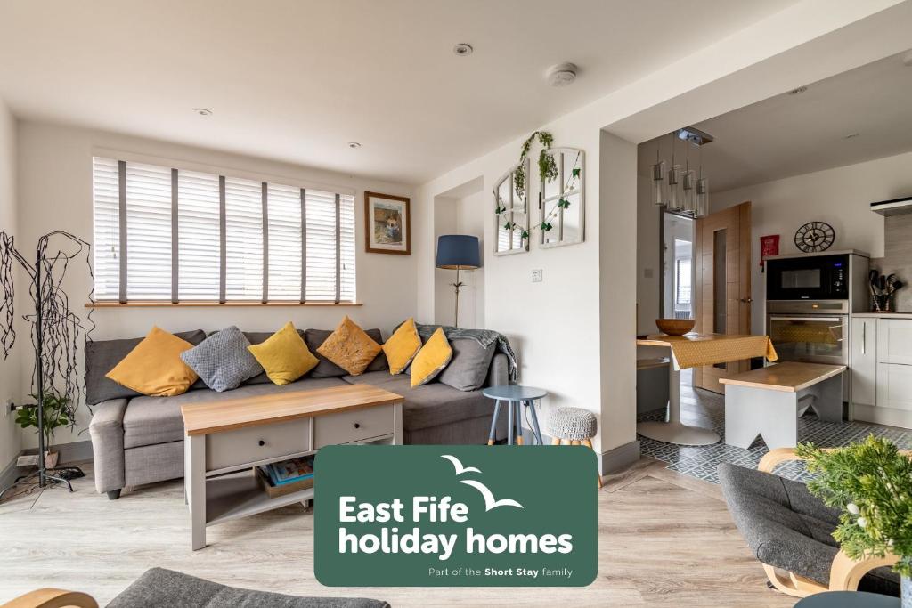 a living room with a couch and a kitchen at Driftwood - Crail in Crail
