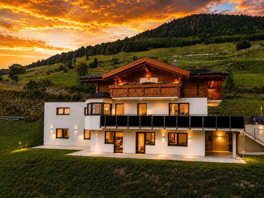 a house on a hill with the sunset in the background at Bergdiamant Nauders in Nauders