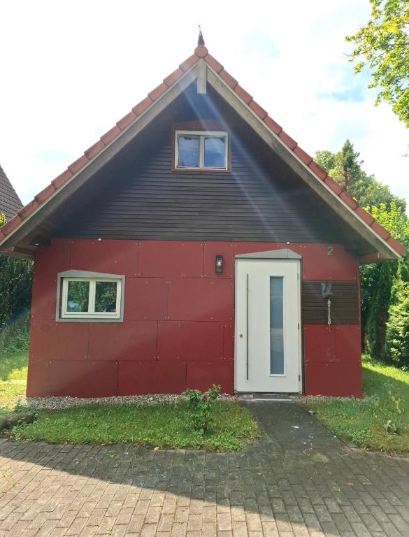 a red building with a white door at Ferienhaus am Schulsee in Mölln
