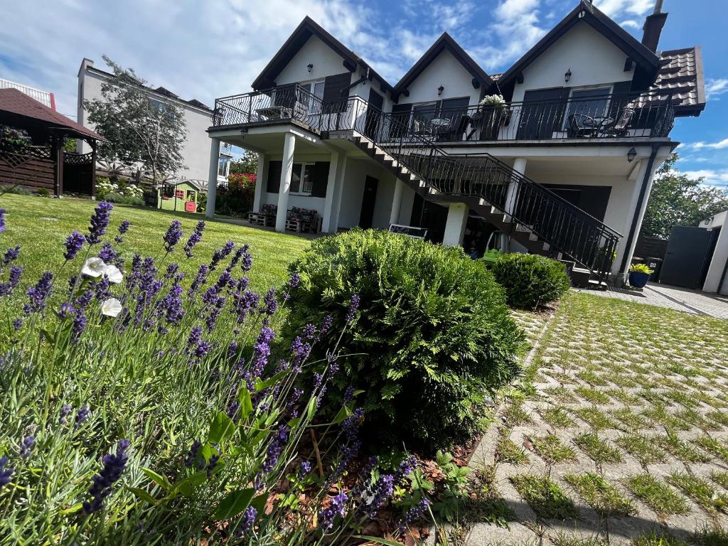 a house with purple flowers in the yard at Andromeda in Mikoszewo