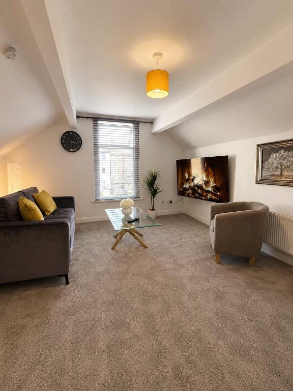 a living room with a couch and a table at New Top Floor Large 1- Bed Flat in Morecambe