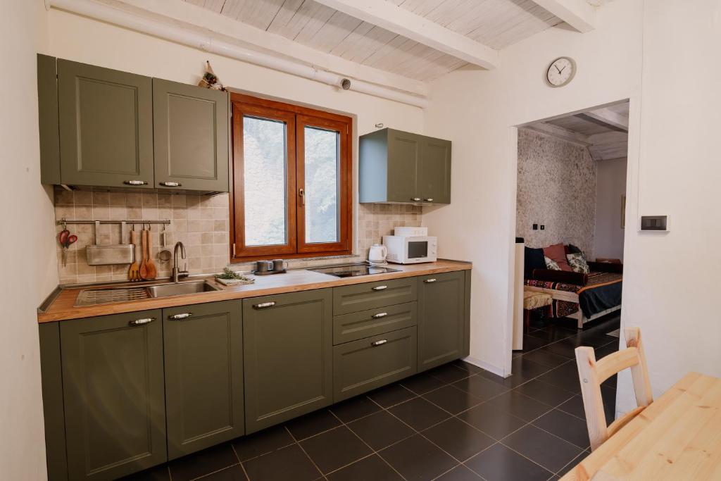 a kitchen with green cabinets and a table in a room at Casa del Bosco in Rubiana