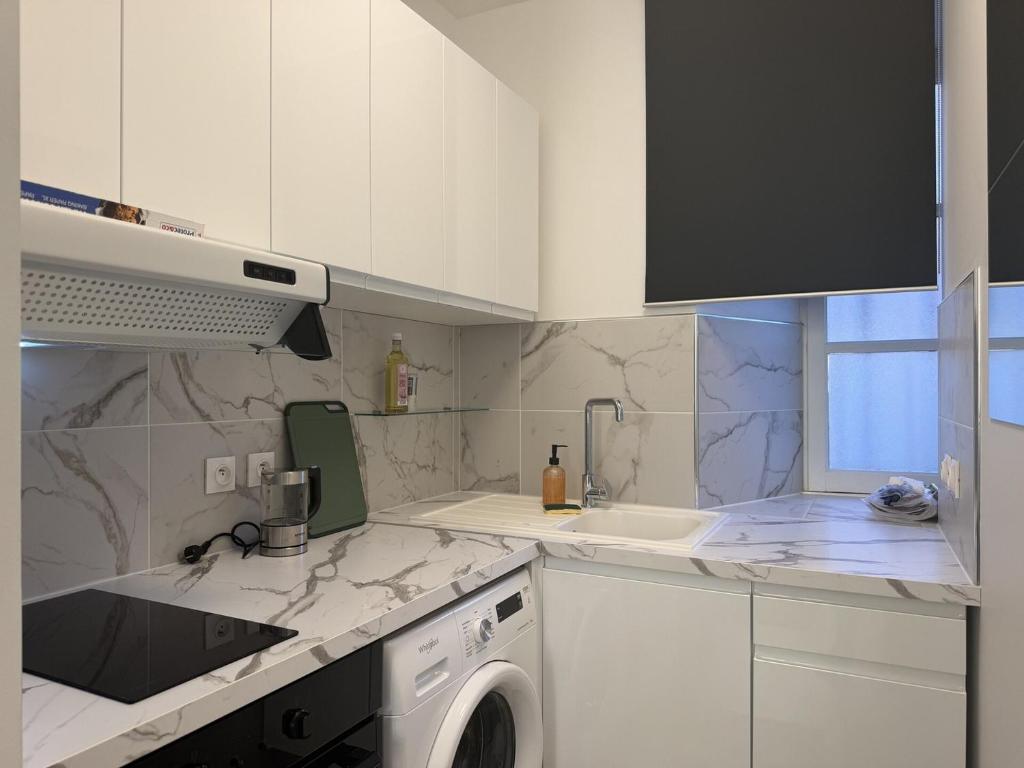 a white kitchen with a sink and a washing machine at La suite Saint Régis 2 in Le Puy-en-Velay