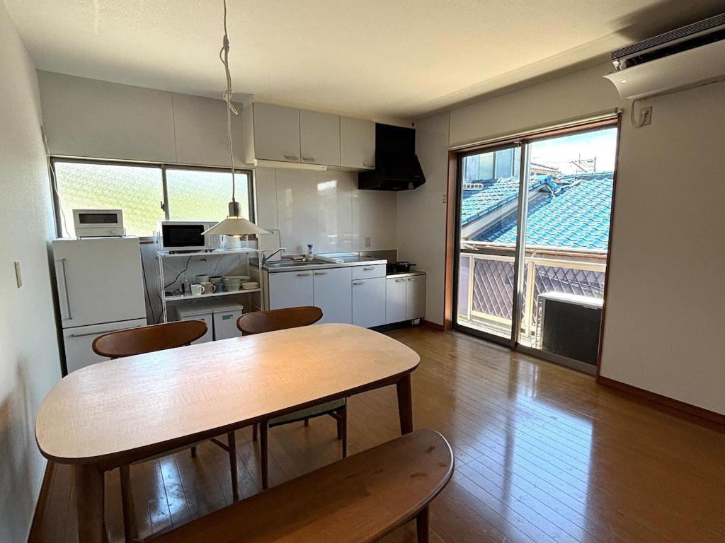 a kitchen with a table and chairs in a room at Flat Dazaifu in Dazaifu