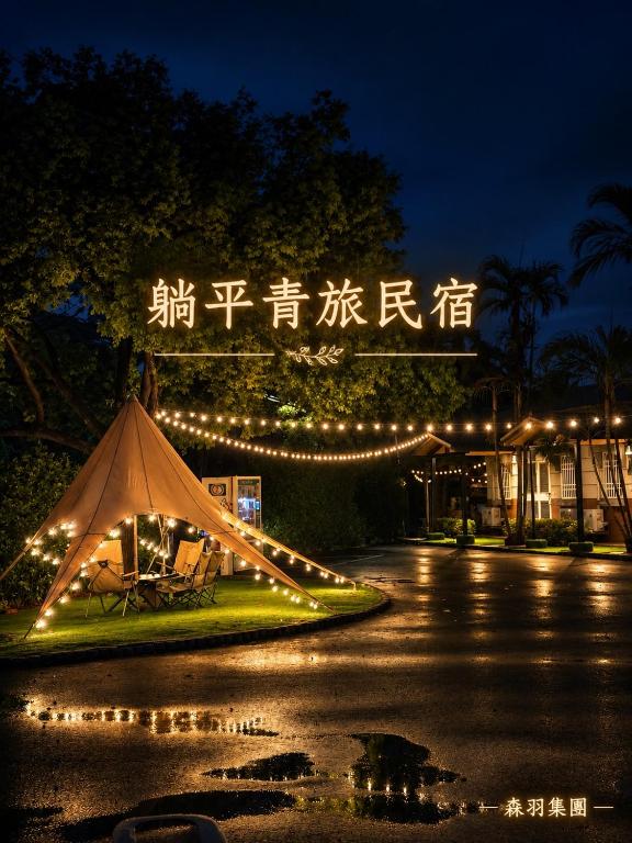 a tent in front of a building with lights at 躺平青旅-住宿推薦 in Minxiong
