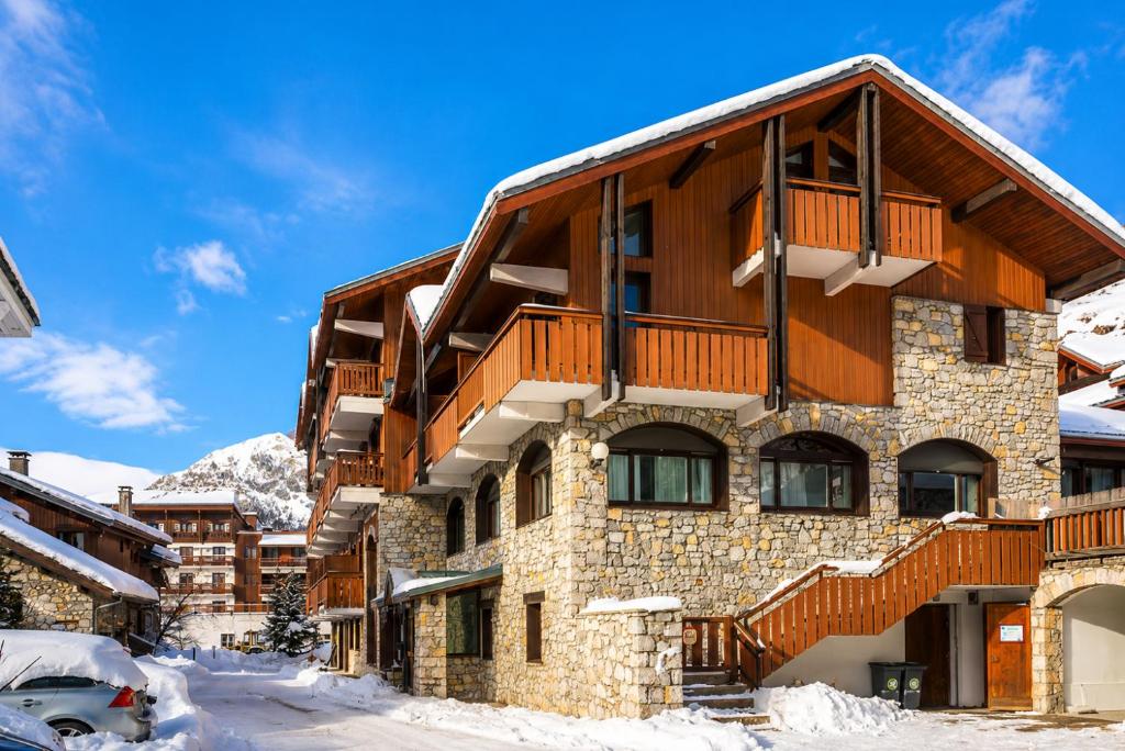 a building with a balcony with snow on the ground at Val d'Isère Centre - Emplacement Idéal in Val-d'Isère
