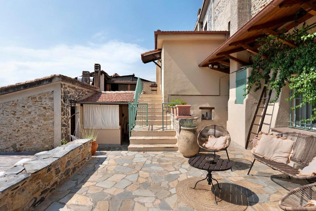 a patio with a chair and a table and a building at La Matrice in Garlenda