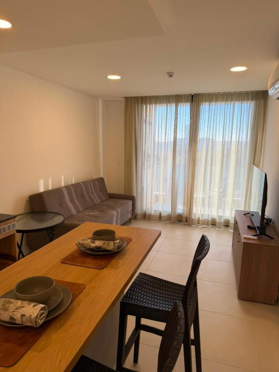 a living room with a table and a couch at Práctico y Cómodo Apartamento en Edificio Vivo Costanera in Encarnación