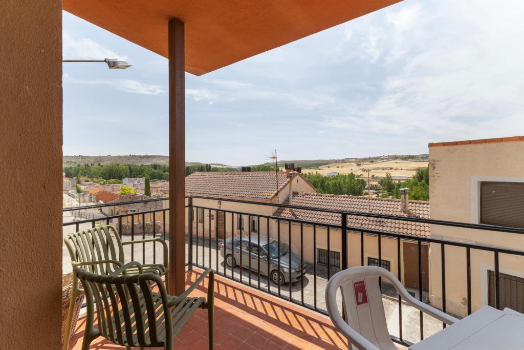 a balcony with two chairs and a view of a car at La Casona de Sacramenia in Sacramenia