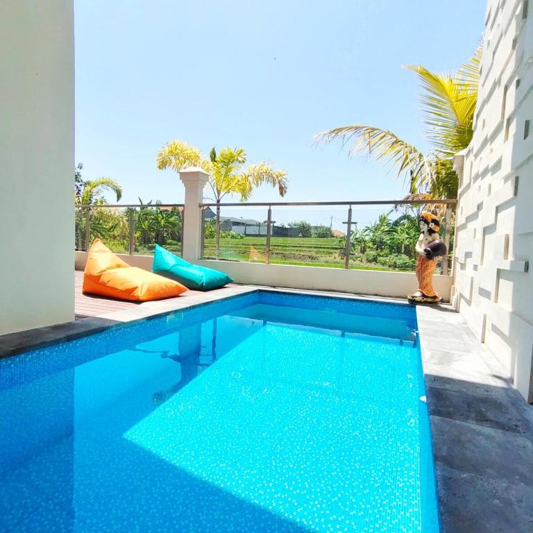 a swimming pool with a person standing next to it at Canggu Rice Field Villa 8B in Dalung