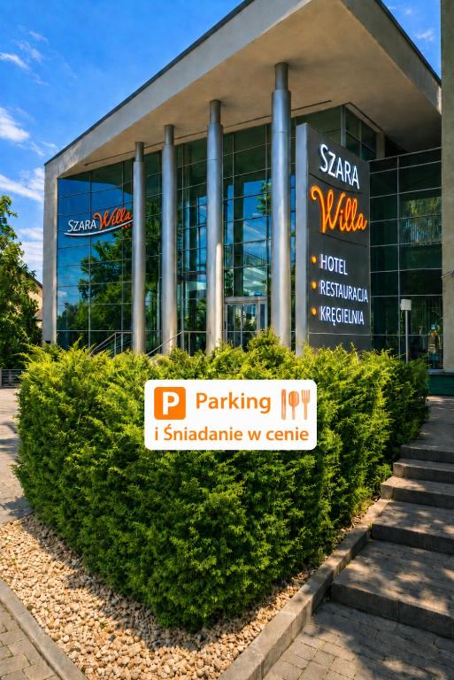 a building with a parking sign in front of it at Hotel Szara Willa in Opole